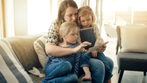 Mother with two children looking at ipad playing French apps for children