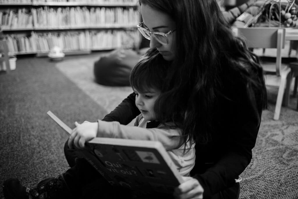 Mom reading to her toddler in the library