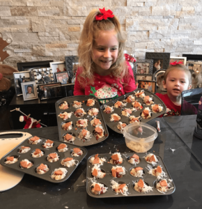 Two young girls proud of their pizza muffins made during a French baking class