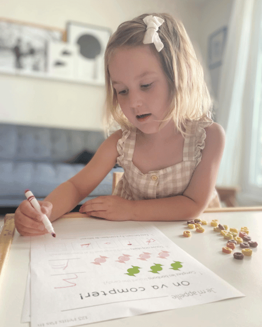 A young girl prepares for school and is writing in her French workbook.