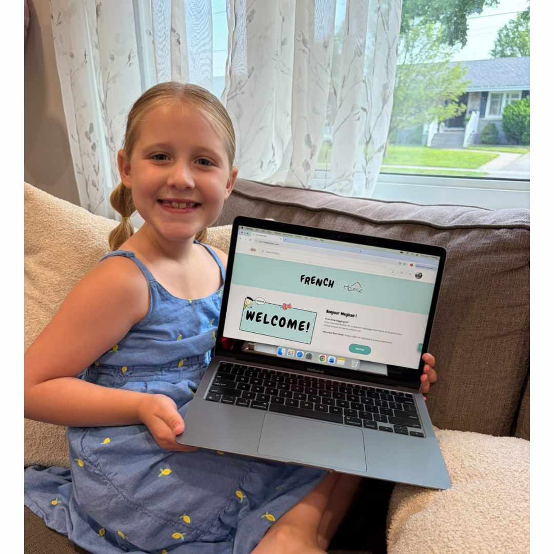 Child showing the French at Home membership on a laptop